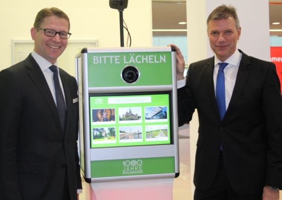 von rechts: Bürgermeister Christoph Tesche und Dr. Michael Schulte von der Sparkasse mit der Fotobox zum Stadtjubiläum.
