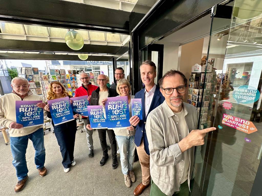 Auch am Kinderladen Siki von Kirsten Stranghöhner (3.v.r.,Westquartier) klebt längst das neue Label am Eingang. Gemeinsam mit Intendant Olaf Kröck präsentierten Georg Gabriel (Abteilungsleiter Stadtmarketing), Sebastian Höber (Altstadtmanager)l, Daniel Michalczik (Quartier Markt/Breite Straße), Andreas Kreyenschulte, Tea Lehwald (beide Quartier Krim) und Wolfgang Rill (Quartier Markt/Breite Straße, v.r.) die gemeinsame Aktion von Ruhrfestspielen und Altstadthandel. Foto: Stadt RE 